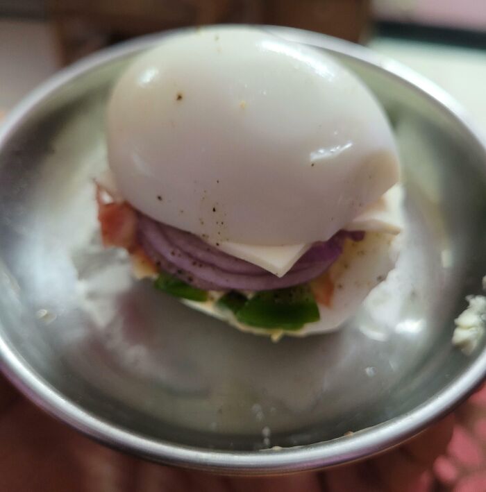 Sándwich creativo de huevo duro con cebolla, queso y verduras que muestra la diversión y humor de los papás. Sándwich creativo de huevo duro con cebolla, queso y verduras que muestra la diversión y humor de los papás.
