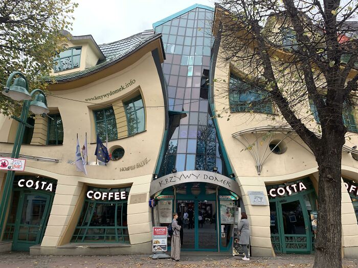 Edificio con diseño arquitectónico ingenioso y curvo en una calle urbana, ejemplo de detalles ingeniosos en la vida cotidiana.