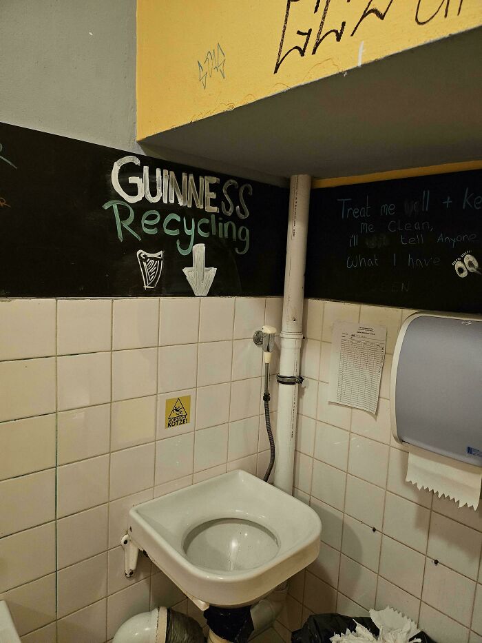 Lavabo con señal de reciclaje Guinness pintada en la pared, detalle ingenioso en la vida cotidiana de varios países.