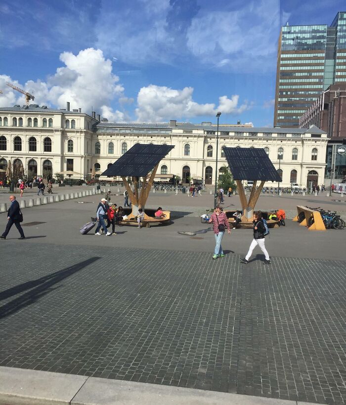 Paneles solares instalados en plaza urbana con bancos para descanso, detalles ingeniosos en la vida cotidiana mundial.