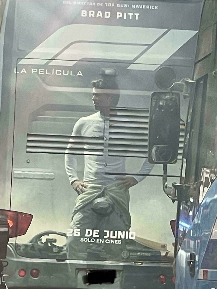 Hombre reflejado en un autobús con una imagen publicitaria que crea un fallo visual divertido y curioso.