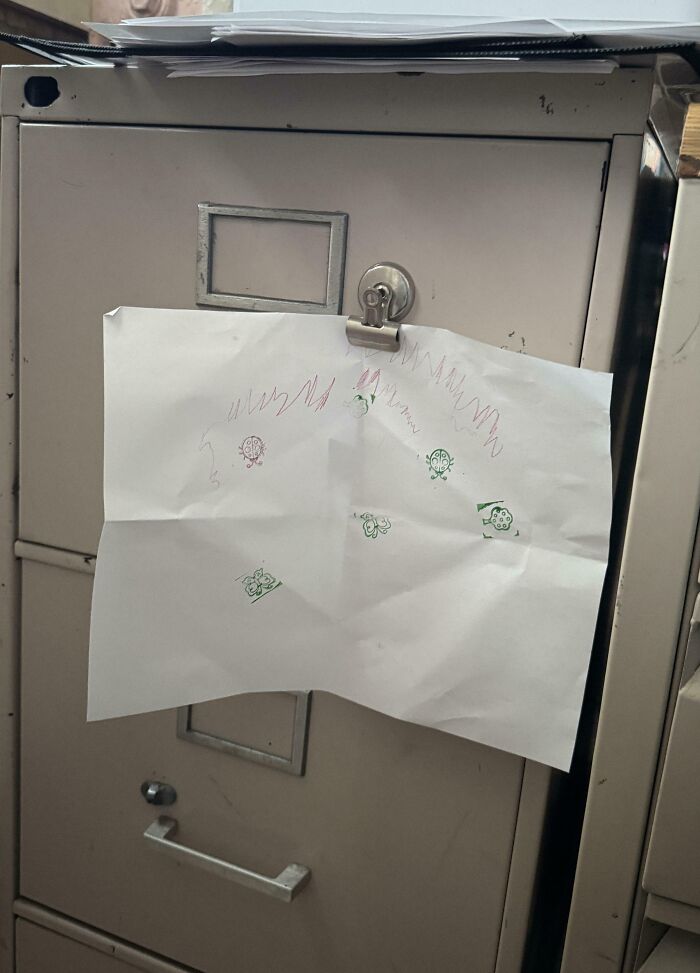 Dibujo infantil con mariquitas colgado en un archivo, mostrando momentos tiernos de padres y crianza divertida.