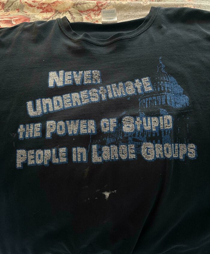 Camiseta negra con texto en inglés, imagen difuminada y desgaste, reflejando el concepto de envejecer como el vino.