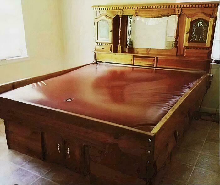 Cama antigua de madera con cabecera tallada y colchón de cuero, objeto del pasado que recuerda la juventud.