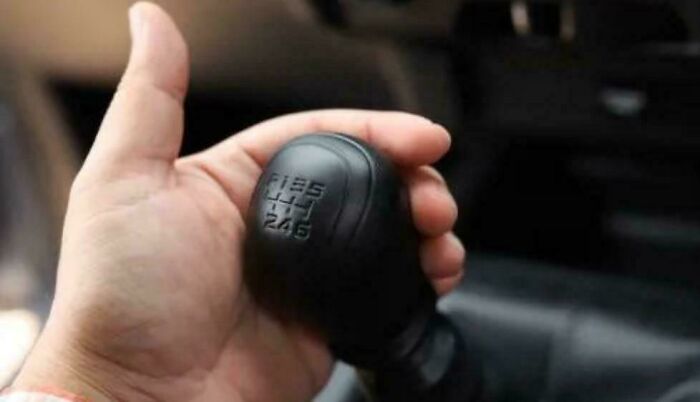 Palanca de cambios manual clásica en mano, mostrando un objeto del pasado que evoca la nostalgia y juventud.