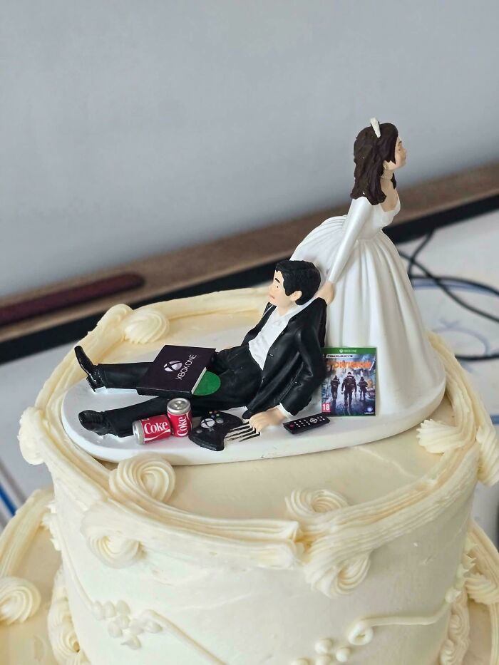 Figura de pastel de boda con pareja donde novio ignora a la novia, mostrando el peor comportamiento en bodas y invitados.