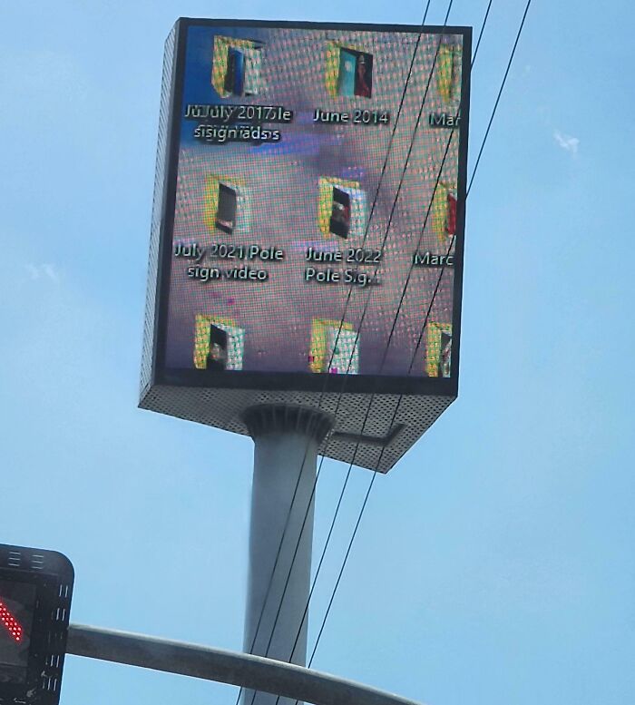 Pantalla publicitaria con error al mostrar el escritorio de una computadora visible desde la calle cielo despejado.