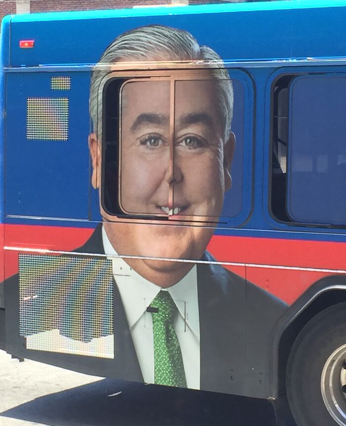 Publicidad divertida con fallo visual en autobús que distorsiona el rostro de un hombre con traje y corbata verde.