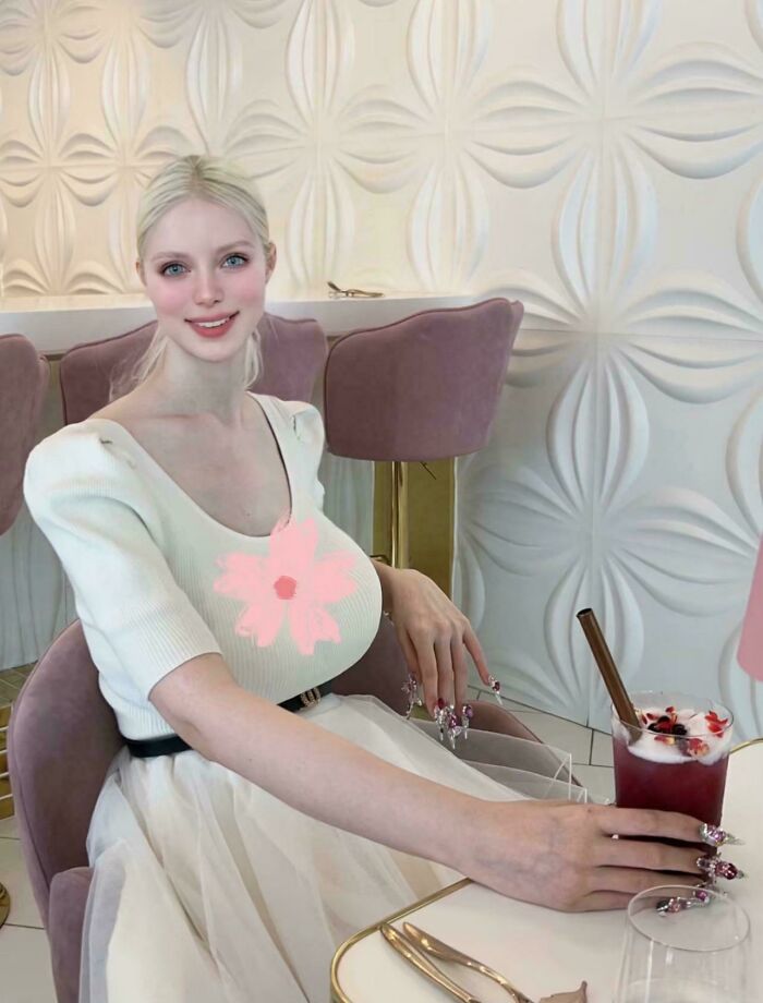 Mujer con vestido blanco en café, momento real que muestra el contraste de Instagram y la realidad visual.