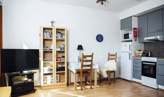 Sala y cocina modernas con muebles de madera y electrodomésticos, destacando cosas interesantes que la gente encontró en casa.