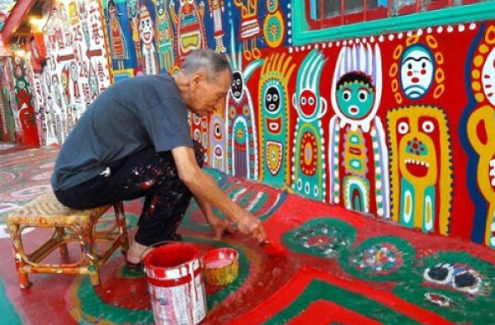 Hombre pintando murales coloridos y creativos con cosas interesantes que la gente encontró para compartir en la comunidad.