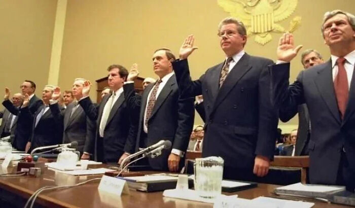 Hombres en trajes formales levantando la mano en audiencia oficial, escena curiosa para cosas interesantes que la gente compartió.