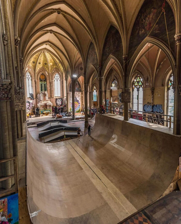 Pista de skate dentro de una iglesia gótica con graffitis y decoración artística, mostrando cosas interesantes que la gente compartió.