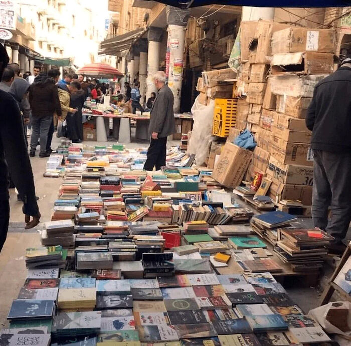 Mercado callejero con gente y libros, mostrando cosas interesantes que la gente tenía para compartir y descubrir.