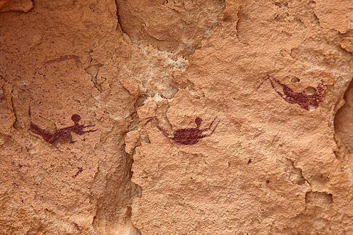 Pinturas rupestres con representaciones humanas en roca, mostrando cosas interesantes que la gente tenía que compartir históricamente.