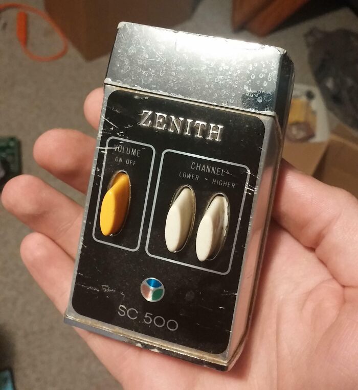 Control remoto Zenith vintage mostrando tecnología y vida cotidiana en la década de 1950 en una mano humana.