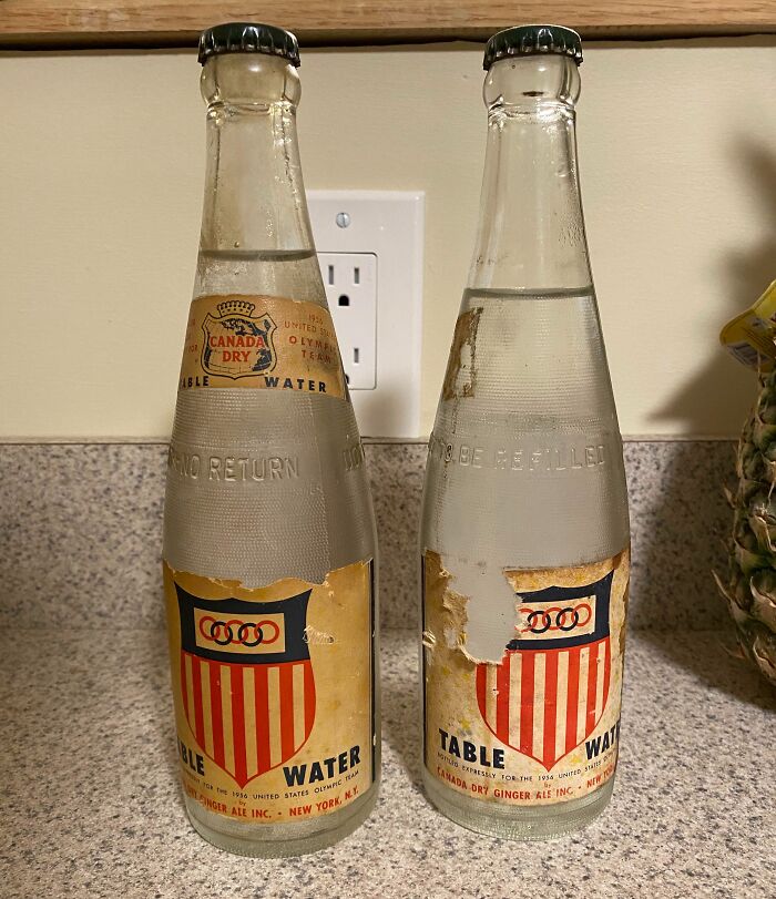 Botellas antiguas de agua de mesa Canada Dry con etiquetas desgastadas, representando la vida cotidiana en la década de 1950.