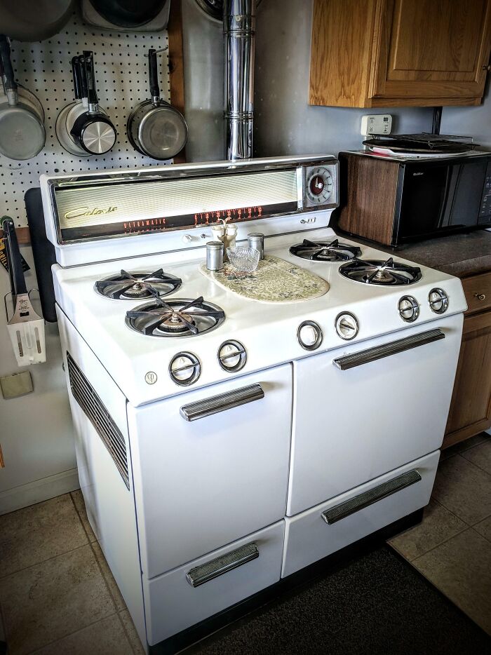 Estufa vintage con utensilios de cocina en cocina tradicional, mostrando la vida cotidiana en la década de 1950.