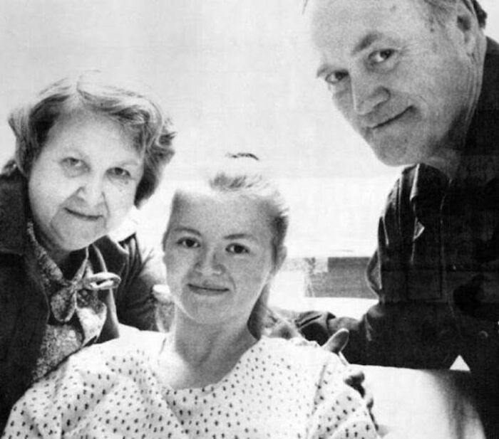 Mujer joven en hospital acompañada por dos adultos, imagen relacionada con datos históricos interesantes y momentos familiares.