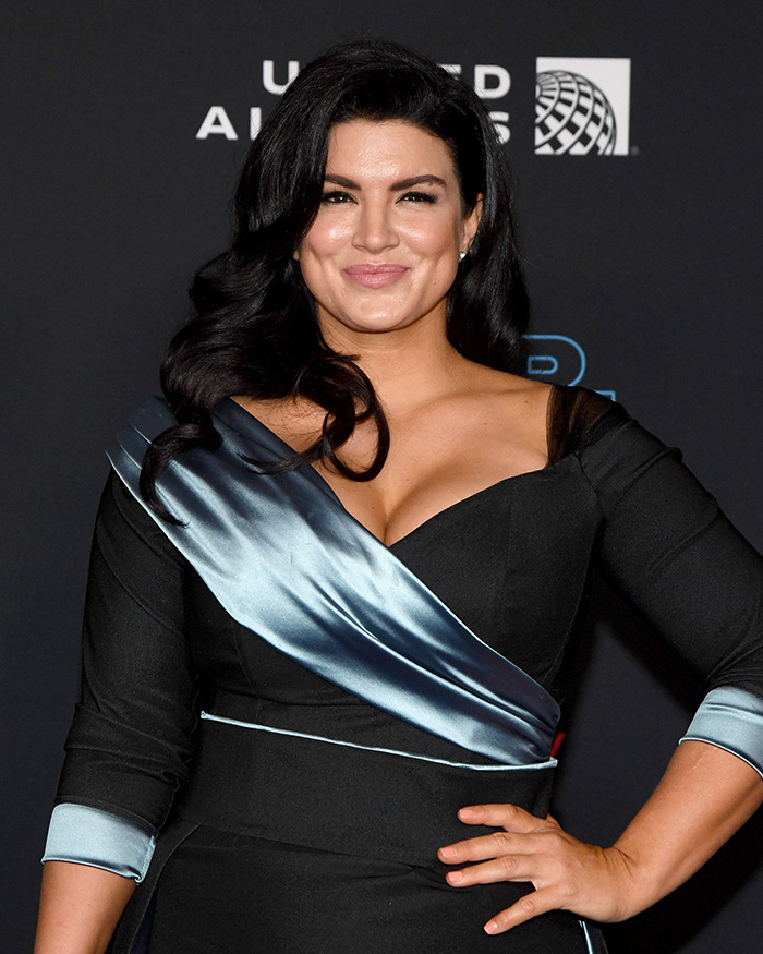 Mujer famosa con vestido negro y detalle azul posando en evento, relacionada con celebridades que arruinaron su reputación.