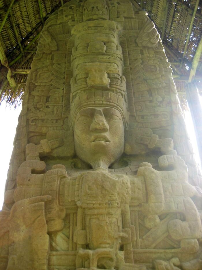 Escultura maya antigua con símbolos y rostros tallados, uno de los misterios interesantes que aún desconciertan a la gente.