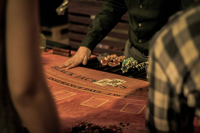 Mesa de blackjack con cartas y fichas, personas jugando y datos sorprendentes para demostrar cuánto desconocemos hoy aprendí.