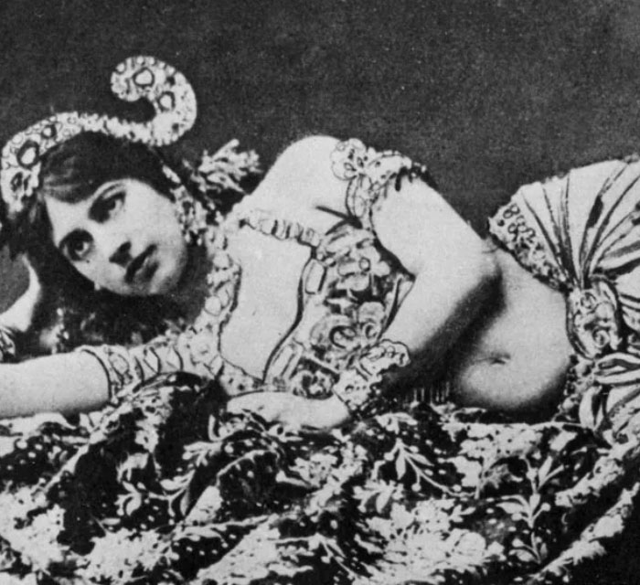 Mujer vestida con traje tradicional posando recostada en tela estampada, ilustrando datos sorprendentes y poco conocidos.