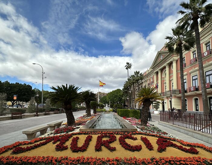 Parque urbano en Murcia con fuentes y flores, ejemplificando momentos famosos que cambiaron el curso de la historia.
