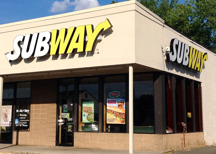 Fachada de local Subway con señalización visible, relacionado con personas con instinto de supervivencia inmaculado.