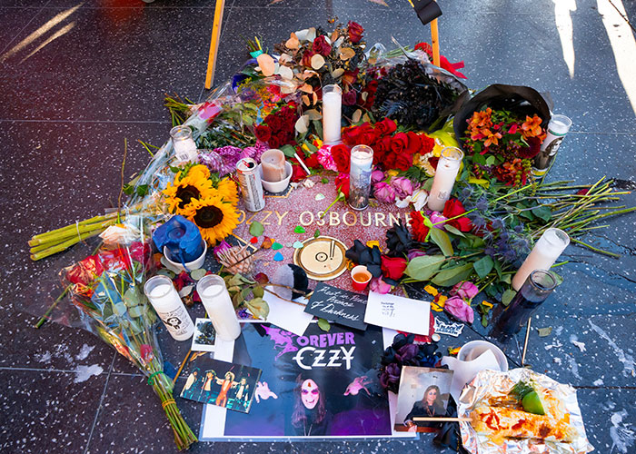 Estrella de Ozzy Osbourne rodeada de flores y velas, reflejando las emotivas declaraciones de Black Sabbath.