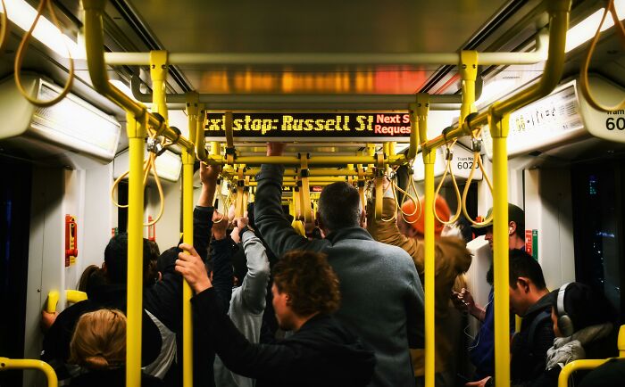 Pasajeros en un transporte público con poca distancia, reflejando personas que ignoraron su intuición y lo lamentaron.