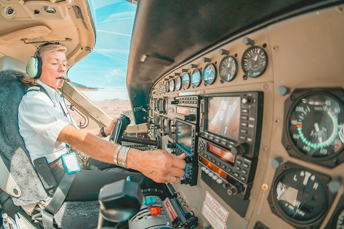 Piloto de avión ajustando controles en cabina, representando el dilema moral y secretos que las empresas ocultan.