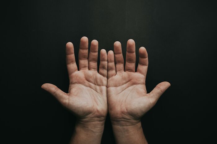 Manos abiertas sobre fondo oscuro, representando los misterios interesantes que aún desconciertan a la gente.