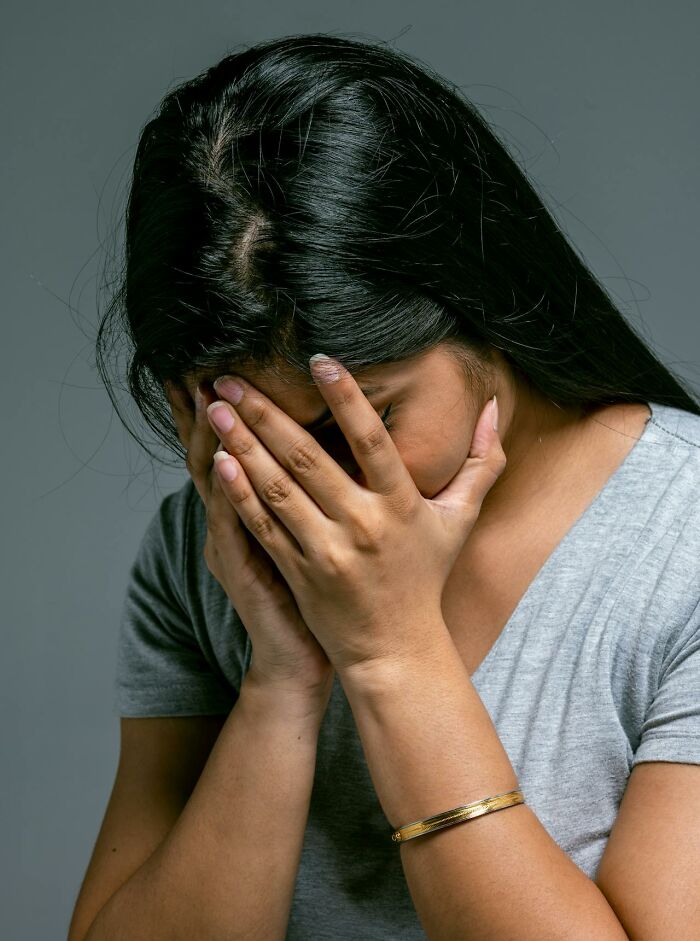 Mujer con expresión de angustia cubriéndose el rostro, simbolizando recuerdos de peores cosas escuchadas accidentalmente.