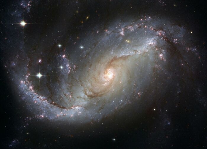Imagen de galaxia espiral con estrellas brillantes en el espacio, representando misterios interesantes que desconciertan a la gente.