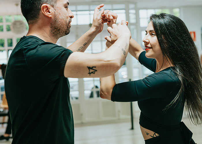 Hombre y mujer practicando defensa personal en un espacio iluminado, ilustrando situaciones raras que enfrentan investigadores privados.