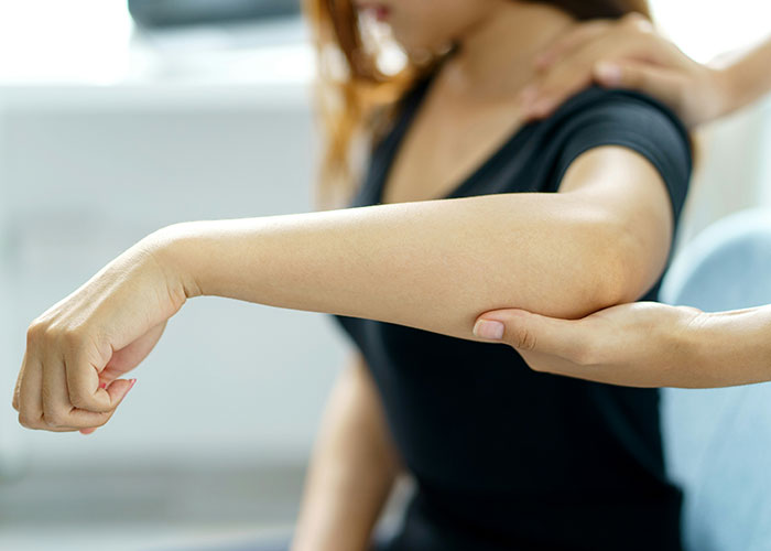 Investigador privado evaluando el brazo de una persona durante una consulta detallada en un ambiente profesional.