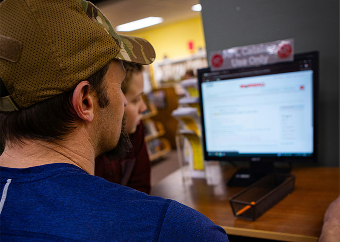 Dos investigadores privados revisando información en una computadora en una oficina de investigación privada.