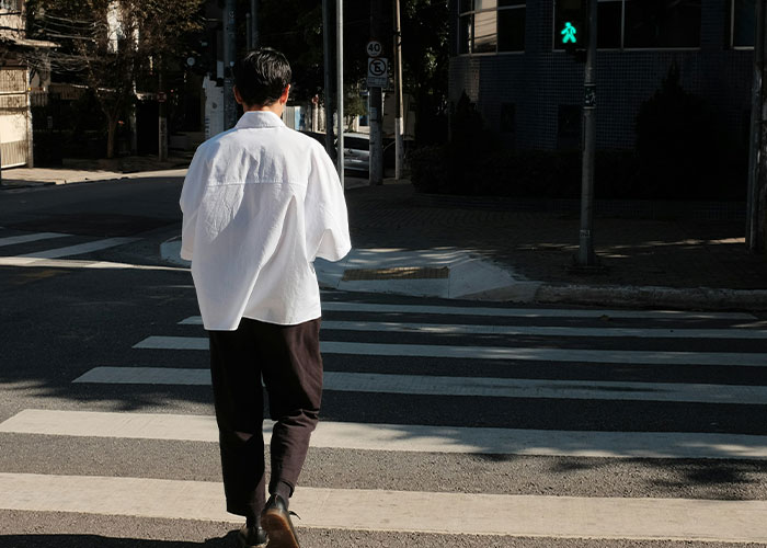 Hombre cruzando calle, ilustrando situaciones extrañas encontradas por investigadores privados en su trabajo diario.