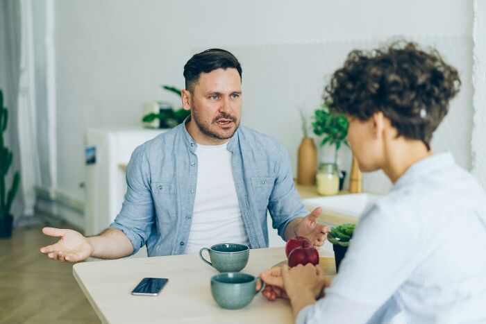 Hombres conversando seriamente en una mesa, representando dilemas morales y secretos que las empresas ocultan a clientes.