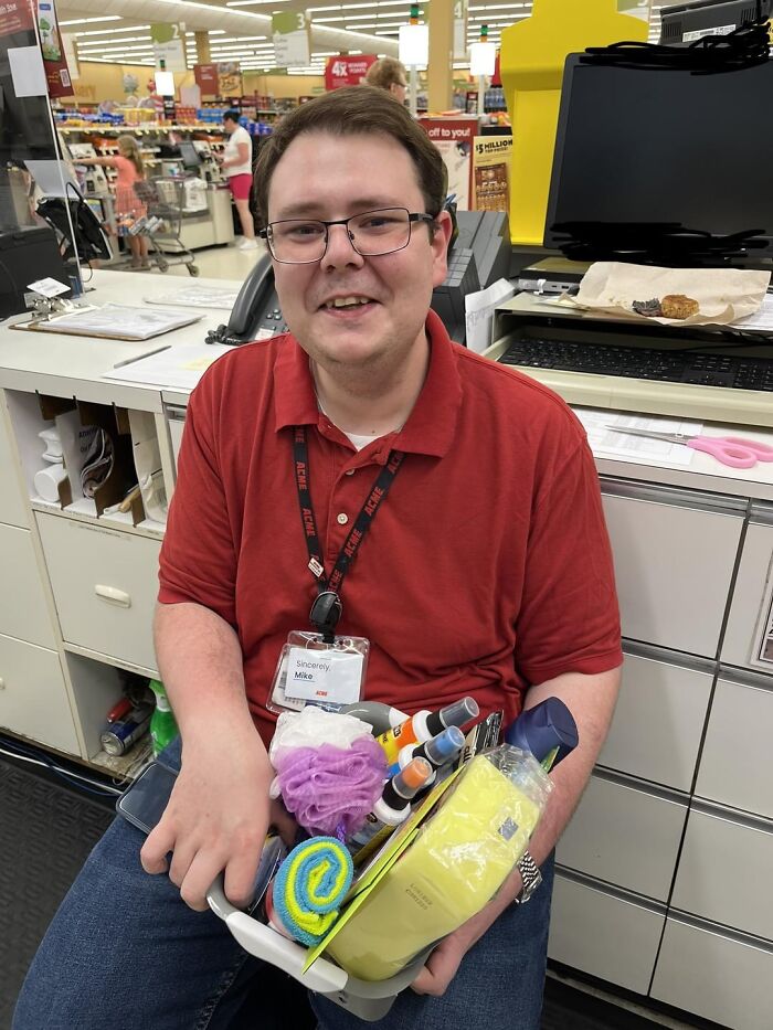 Hombre sonriente en tienda con productos de limpieza, ilustrando publicaciones reconfortantes para distraerte del mundo actual.