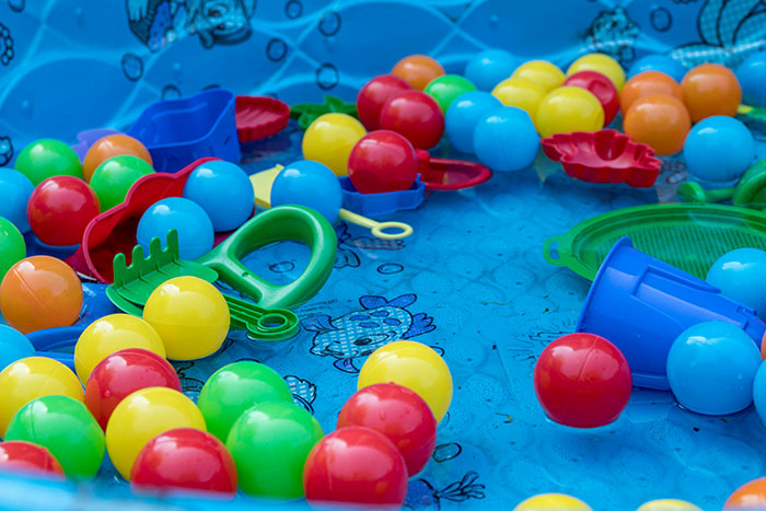Juguetes y pelotas de colores en piscina de plástico para niños relacionados con experiencias con psicópatas.
