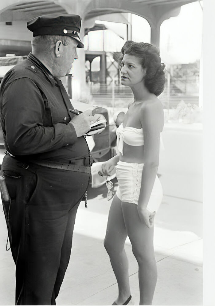 Policía hablando con mujer en traje de baño en una imagen antigua que muestra contexto de fotos viejas históricas.