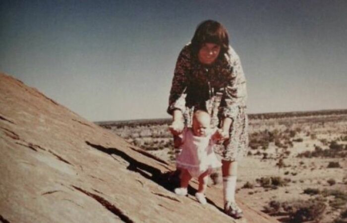 Mujer ayudando a un bebé a caminar en una roca pendiente, imagen que ilustra datos curiosos y morbosos impactantes.