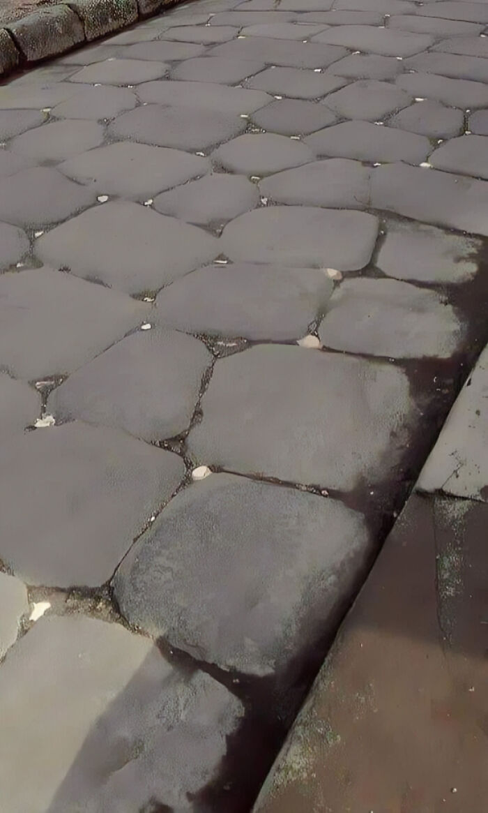 Calle adoquinada antigua con piedras grandes y desgaste visible, mostrando historia en fotos viejas poco conocidas.