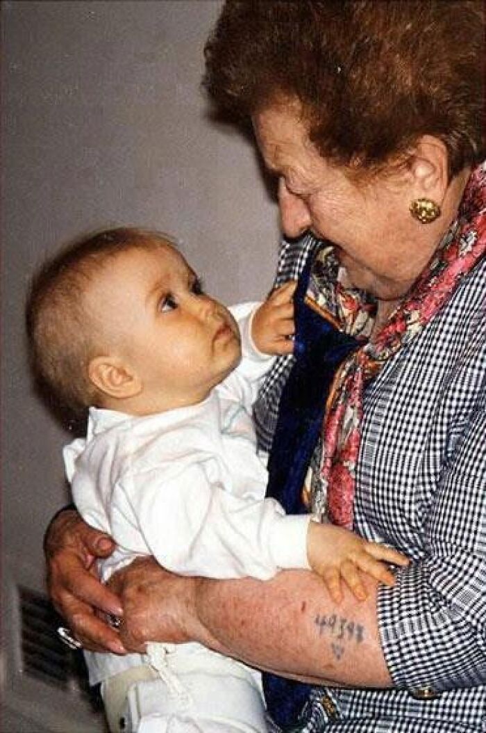 Anciana con tatuaje numérico en el brazo sosteniendo a un bebé en una de las cuarenta y cinco fotos antiguas.
