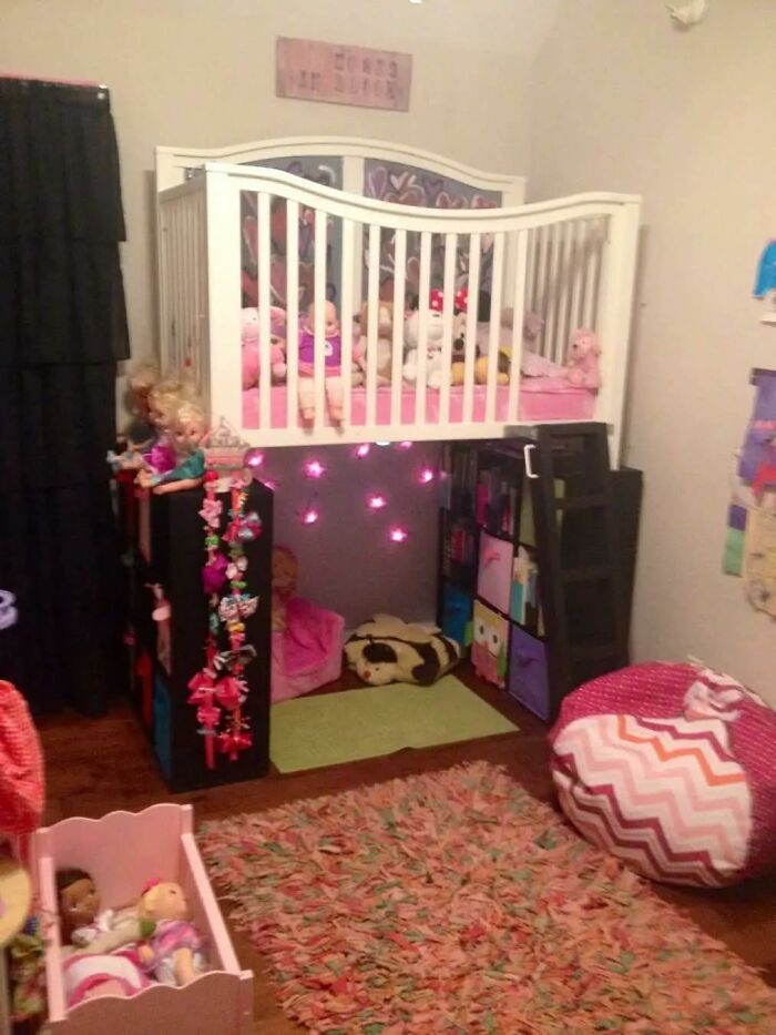 Cama elevada para niños con diseño DIY fallido, juguetes y luces decorativas en habitación desordenada y pequeña.