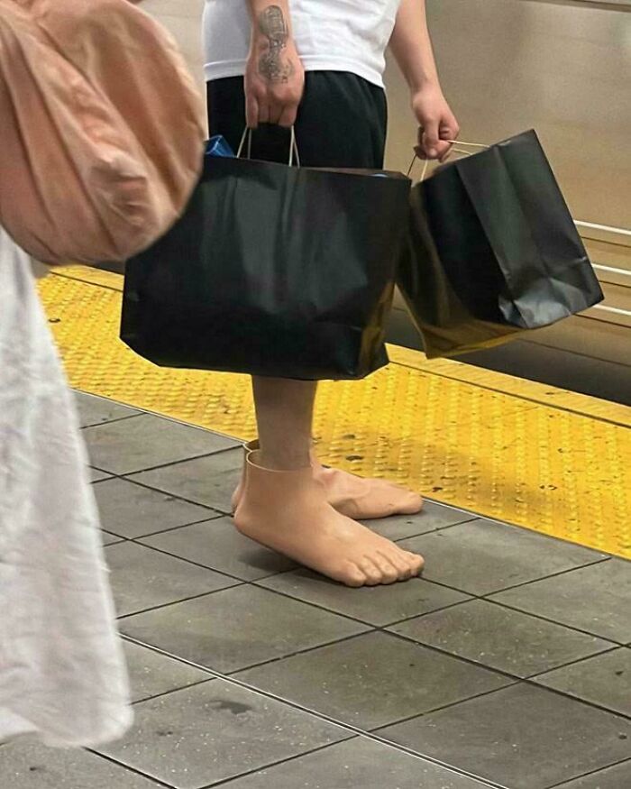 Persona con habilidades para hacer realidad ideas horribles, usando zapatos que parecen pies desnudos y bolsas negras en las manos.