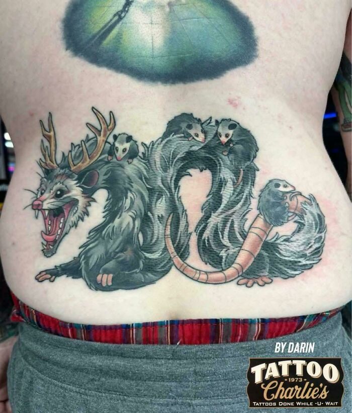 Tatuaje creativo en la espalda con diseño único de criatura fantástica que muestra habilidades para hacer ideas impactantes realidad.