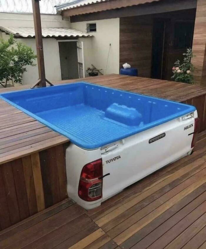 Piscina improvisada con habilidades para hacer realidad ideas malas, usando parte trasera de camioneta Toyota integrada en deck de madera.